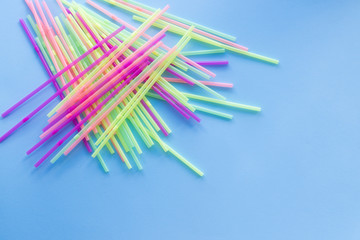 Colored plastic drinking straws on a blue background