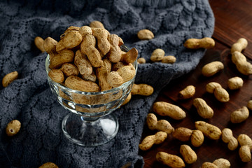Peanuts in a bowl on the dark background. Peanuts in a shell. Healthy food.