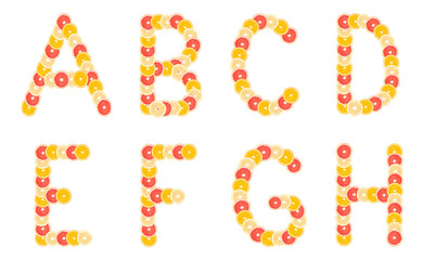 Alphabet made from sliced citrus fruits. Oranges, grapefruits. Isolated on a white background.