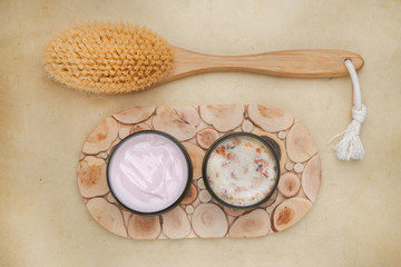Fototapeta na wymiar cream lotion, scrub, body brush on wooden surface