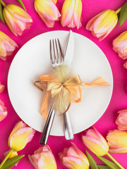 Easter table cutlery with tulips, feathers and bow