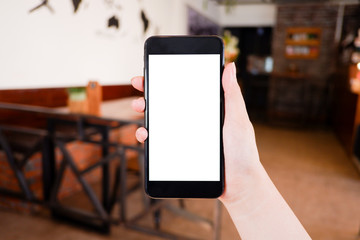 Mockup picture of business woman’s hands holding smart phone with white blank screen in modern place.