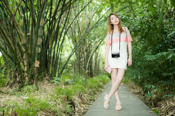 portrait asian woman with camera standing in green tree nature