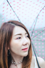 close-up portrait beautiful asian woman with pink umbrella. selective focus
