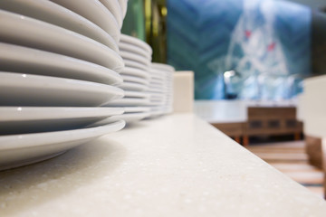 White ceramic dish plate stack row on clean desk table and natural interior design wallpaper art background in organic vegetarian vegan fresh salad catering bistro bar for serve healthy food dining