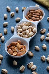 Roasted Nuts And Salted Pistachios In White Ceramic Bowl
