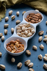 Roasted Nuts And Salted Pistachios In White Ceramic Bowl