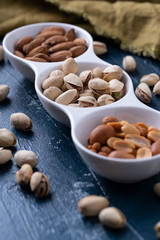 Roasted Nuts And Salted Pistachios In White Ceramic Bowl