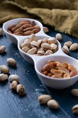 Roasted Nuts And Salted Pistachios In White Ceramic Bowl
