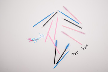 Top view on eyelash extension tools. Flatlay of multi-colored brushes for combing cilia.