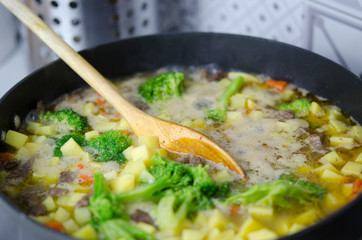 Vegetable stew with meat boils in a large pot. Close up. Healthy diet.