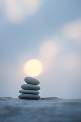 pyramid of stones by the sea at dawn. balanced zen stones. 