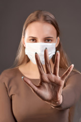 Close-up of a girl's hand in a medical mask. Protection from viruses, preservation of health.