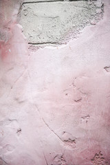 Close up of soft pink painted damaged plaster wall