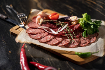 plate of salami ham sausage on a wooden board with sauce