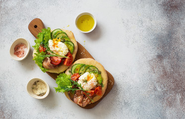 Two loaf of bread with poached eggs and fresh vegetables
