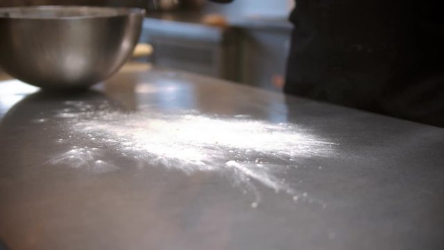 Chef throwing flour on the table before making dough