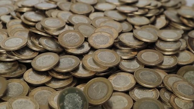 A lot of mexican coins where more coins are falling down