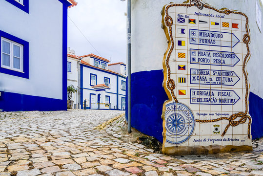 View in the streets of Ericeira, traditional white houses with blue stripes, Portugal