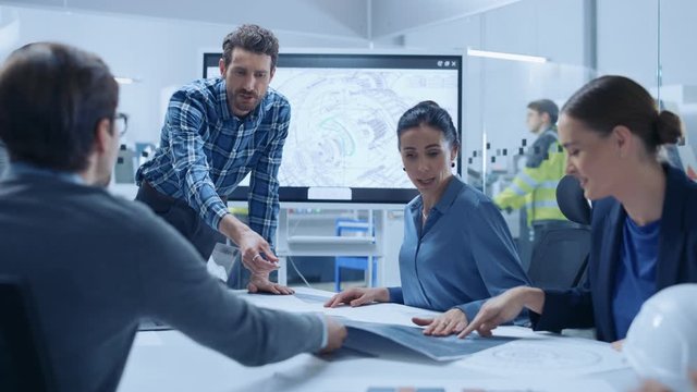Modern Factory Office Meeting Room: Busy Diverse Team of Engineers, Managers and Investors Talking at Conference Table, Use Interactive TV, Analyze, Find Solutions, Debate and Discuss Engine Concept