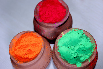 Traditional color celebration, Bright colors in clay pot for Indian Holi Festival, Organic Gulal colors pattern.