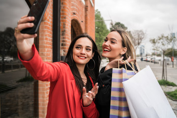 Two young friends taking a selfie with mobile phone.