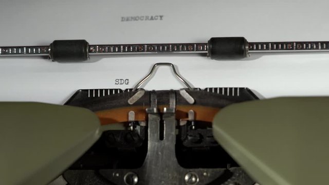 SDG and DEMOCRACY written on old green vintage retro typewriter 4k with sound the 17 UN sustainable developement goals with sound