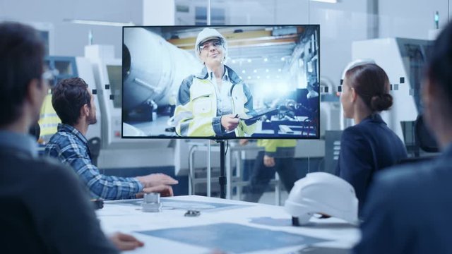 Diverse Group of Specialists, Managers in the Factory Office Meeting Room, Have Conference Video Call with Factory Chief Female Engineer, She Talks about Production Growth, Uses Tablet Computer
