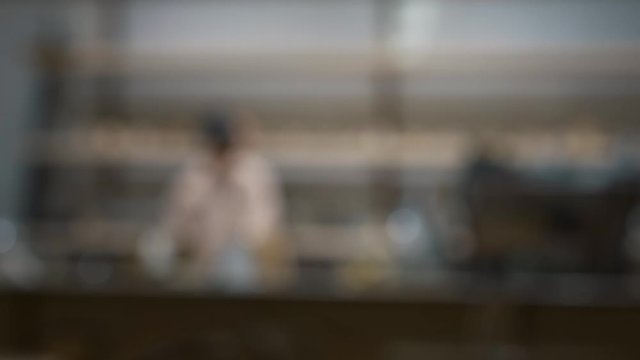 Profile of blurred, bokeh silhouette of two men working indoors. Abstract blur of two men workers in the restaurant, and groom silhouette profile view
