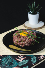 Steak tartar with egg on black plate