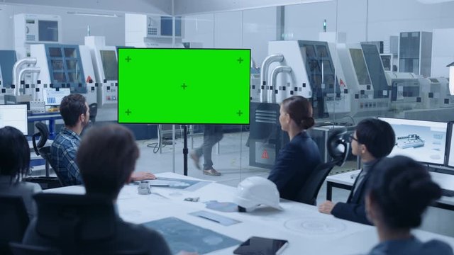 Modern Factory Office Room: Diverse Team of Engineers, Managers and Investors Sitting at Meeting Table, They wave at Interactive TV that shows Green Screen Video Call Conference