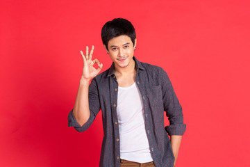 portrait young man in casual dress okey hand sign