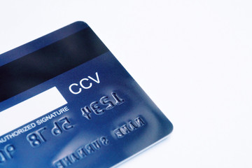 Back side of dark blue credit card with space for card holder to sign and its CCV number on white background. Credit card security for card holder when using at stores and online shopping concept 