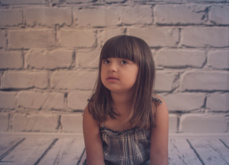 Little girl is sitting and looks to the side