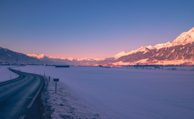 road in alpine valley in winter