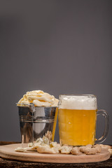 different cheese classic choice, on an old wooden board, nuts, snacks and a glass of beer and