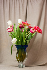 Beautiful bouquets of different colors in a vase on a gray background