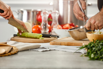Hands in kitchen making meal.Table of free space for your decoration and fresh vegetables. 