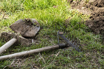 garden preparation in spring, tillage, metal garden harrow and digging shovel,