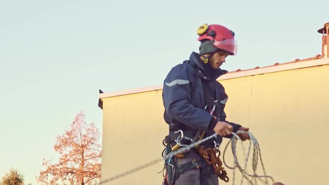 Rope access engineer abseiler with safety harness is working 