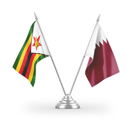 Qatar and Zimbabwe table flags isolated on white 3D rendering