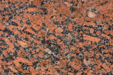 Granite surface in orange, cherry, gray, white, black mix. Copy space. Minimalism. 