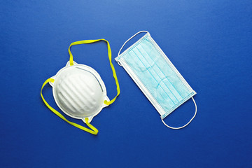 Two types of protective face masks on blue background precaution for coronavirus