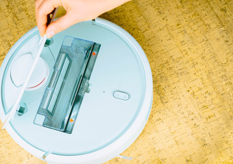 A robot vacuum cleaner cleans the floor of a house. Modern technology for comfort. Smart House. Easy life. Help around the house.