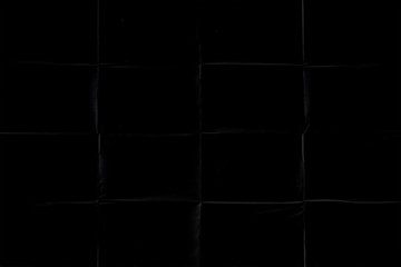 black crumpled paper texture with folds, black background, wallpaper.