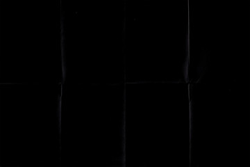 Naklejka premium black crumpled paper texture with folds, black background, wallpaper.