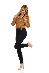 Cheerful Young Woman In High Heels Is Standing On One Leg And Looking Down