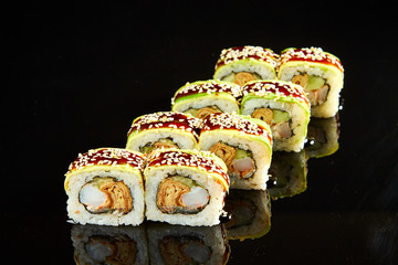 Traditional sushi roll with shrimps, cream cheese and egg omlet on black stone. Japanese food