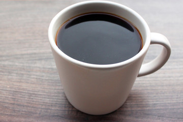 coffee mug standing outside on a wooden surface