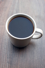 coffee mug standing outside on a wooden surface